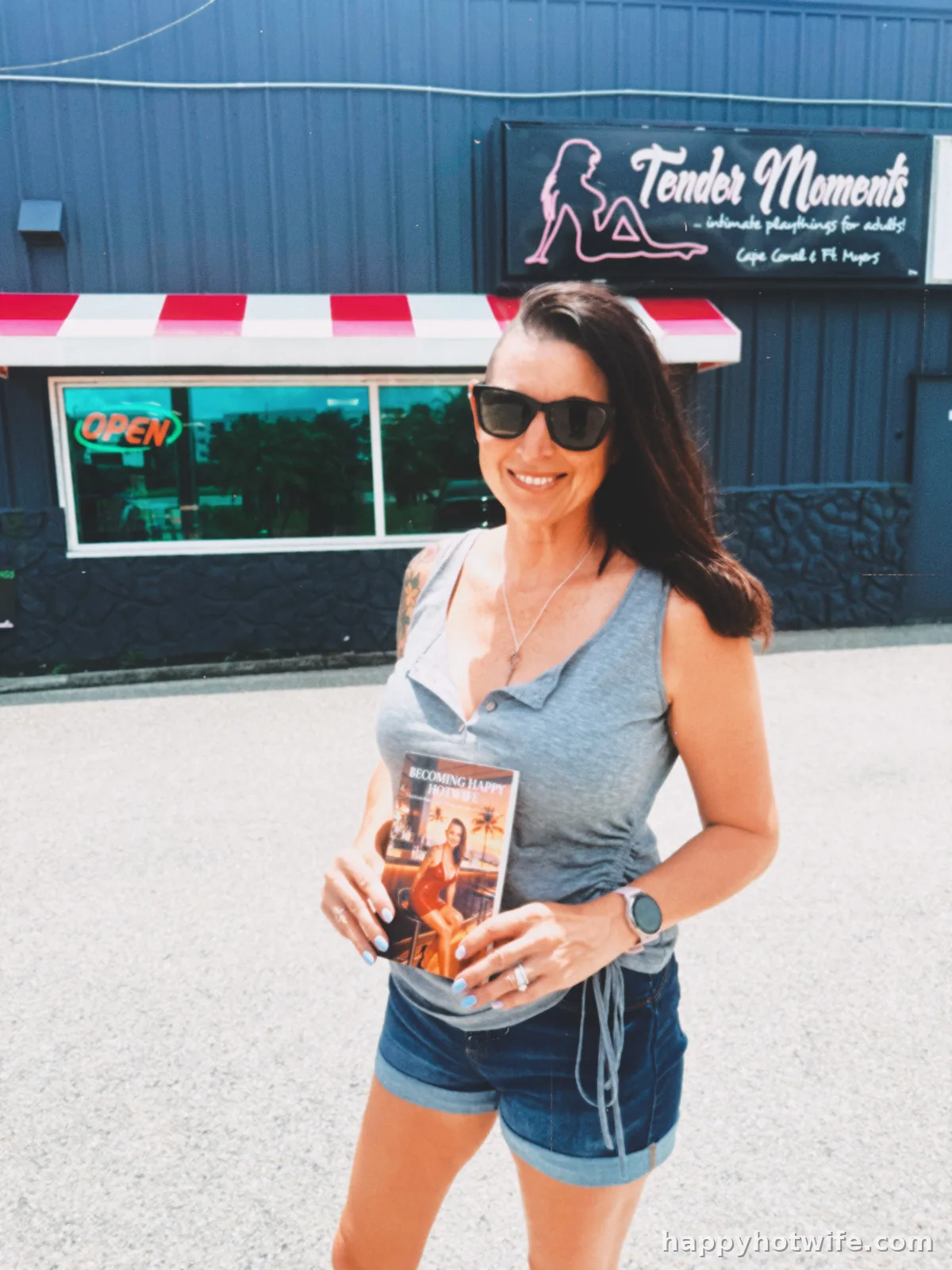 Happy Hotwife holding her book Becoming Happy Hotwife outside Tender Moments adult store in Cape Coral, Florida