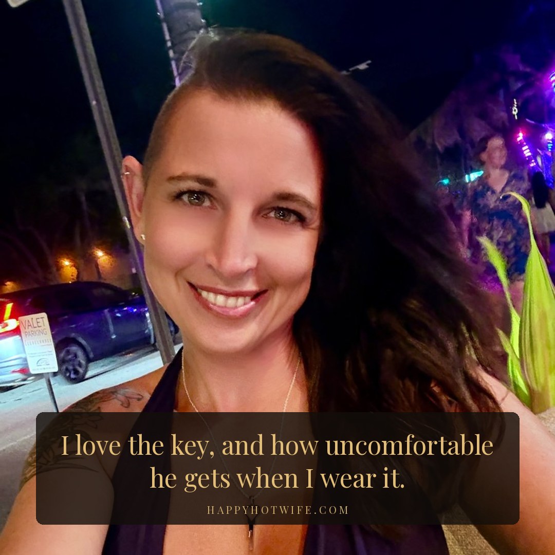 "I love the key, and how uncomfortable he gets when I wear it." Quote from Becoming Happy Hotwife. Happy Hotwife on a night out in a navy halter, wearing the heart key necklace to her husband's chastity cage.
