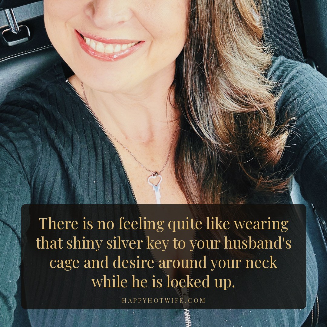"There is no feeling quite like wearing that shiny silver key to your husband's cage and desire around your neck while he is locked up." Quote from Becoming Happy Hotwife. Happy Hotwife wearing her key necklace in a black zip top.
